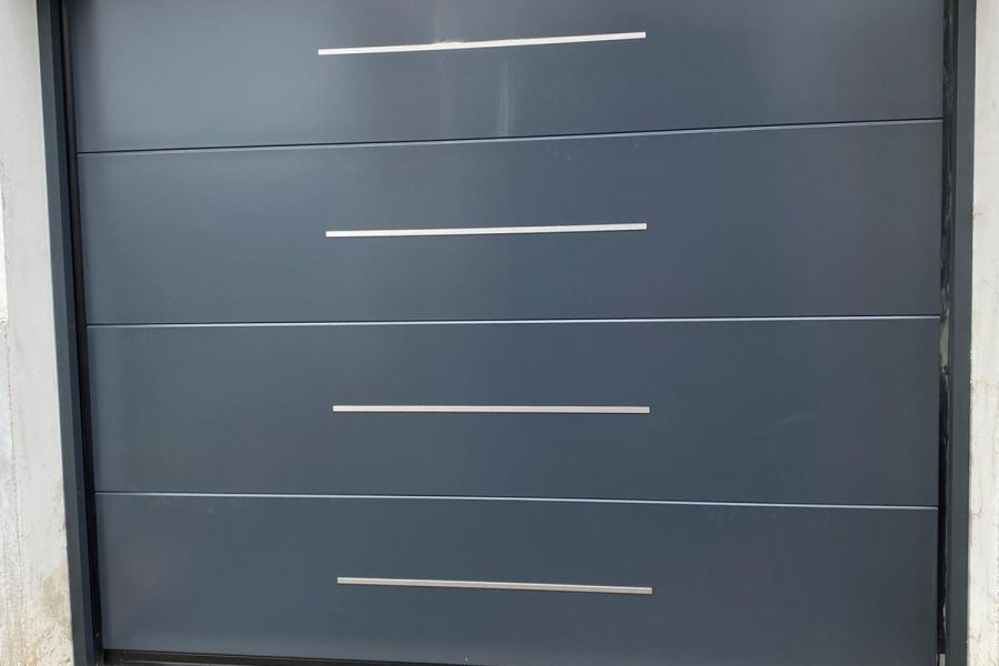 Porte de garage sectionnelle en aluminium laquée gris anthracite avec motifs horizontaux et manoeuvre motorisée