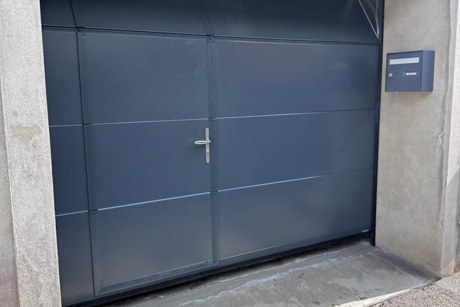 Porte de garage sectionnelle en aluminium laquée gris anthracite avec épaisseur de 42mm isolante avec un design lisse avec une porte