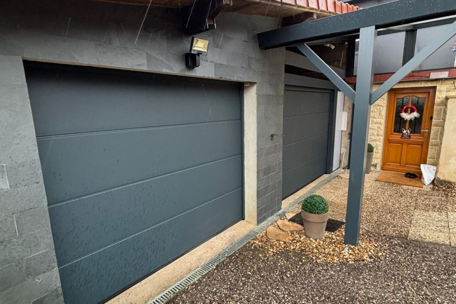 Portes de garages sectionnelles en aluminium laquées gris anthracite avec manoeuvre motorisée et design lisse