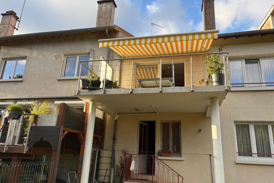 Store banne motorisé avec commande radio avec toile décorative jaune et blanche avec ossature blanche et bras avec leds intégrés