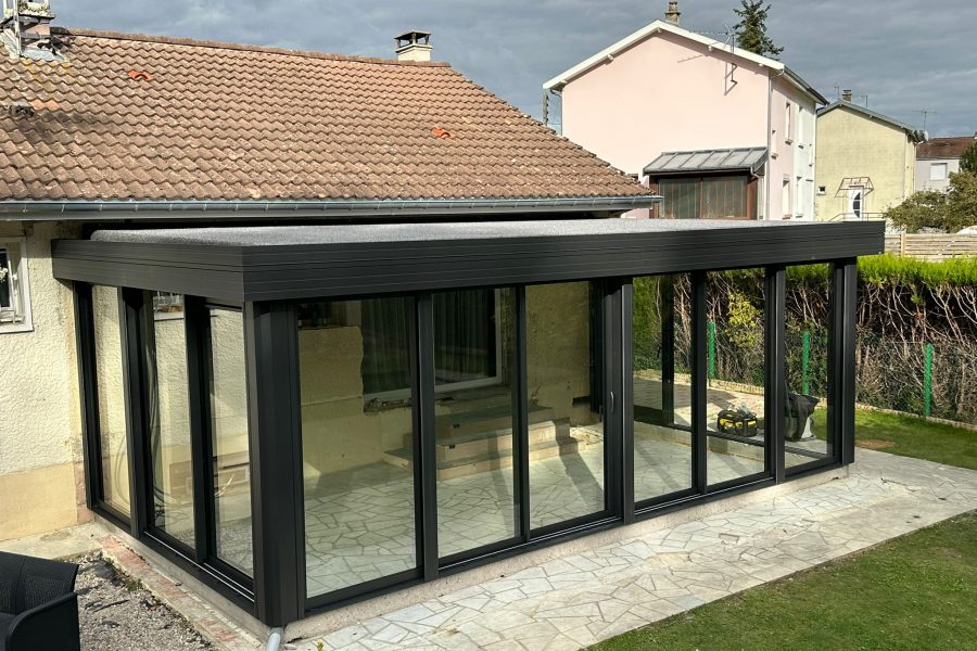 Véranda en aluminium laqué gris anthracite avec toiture en aluminium isolé 85mm blanc intérieur/gazon synthétique isophonique extérieur