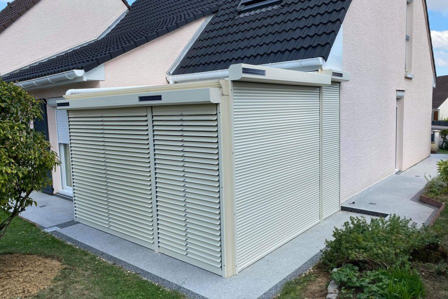 Volets roulants solaires motorisés en aluminium avec une pose sur véranda existante laqué ivoire clair avec capteurs solaires